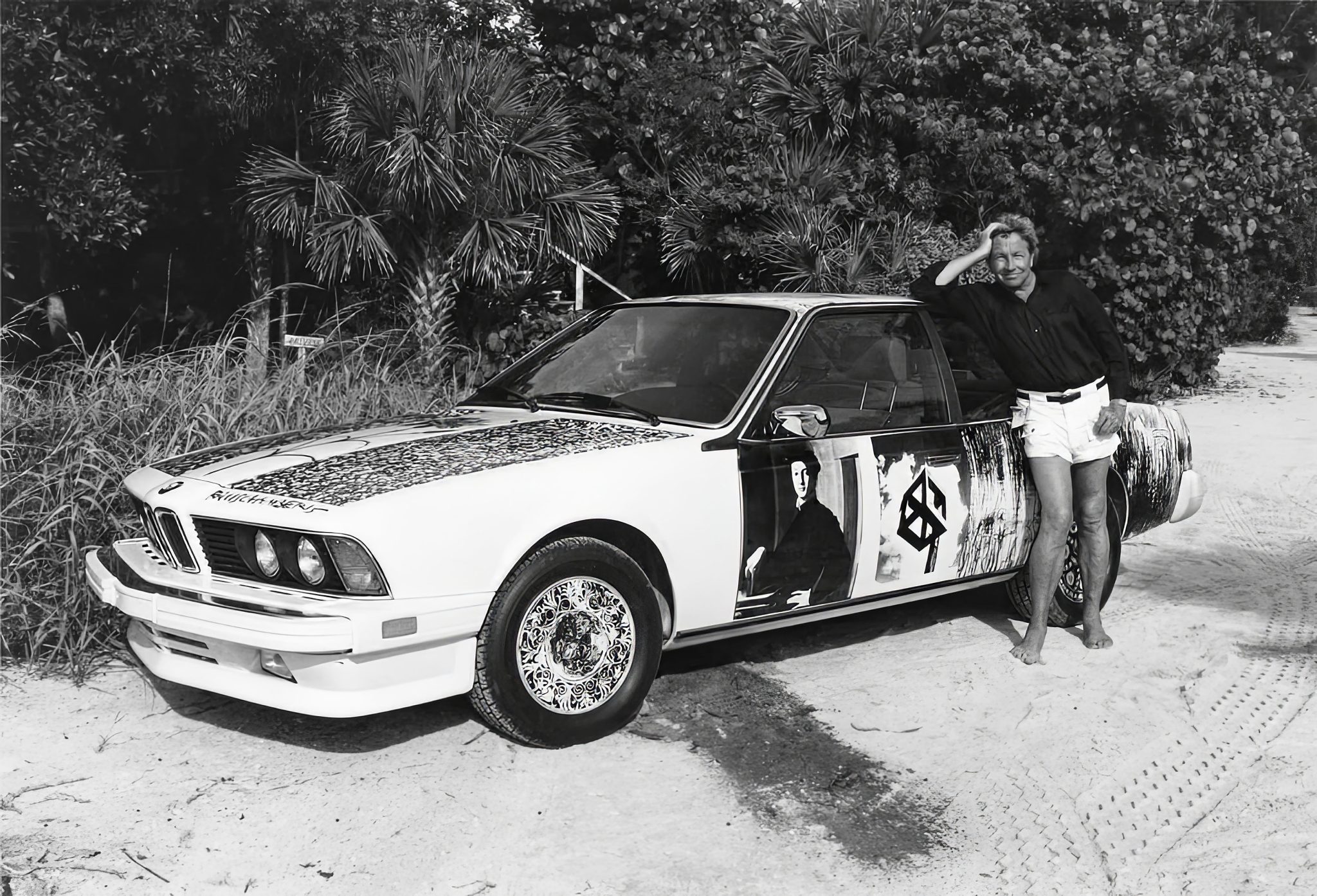 Robert Rauschenberg with his BMW art Car on the beach.