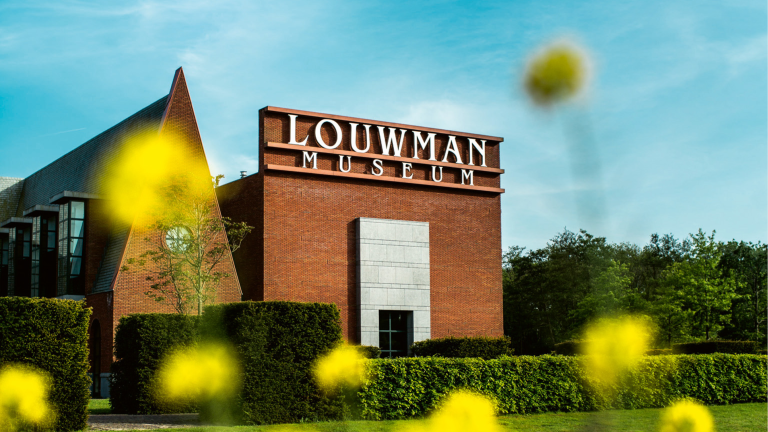 Buitenkant van het Louwman Museum gezien door bloemetjes heen